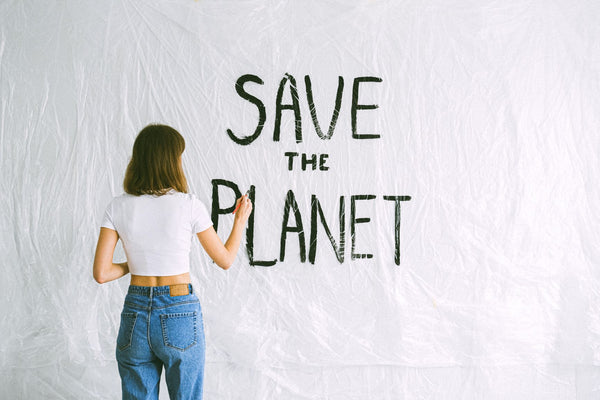 Girl painting on a wall Save the Planet