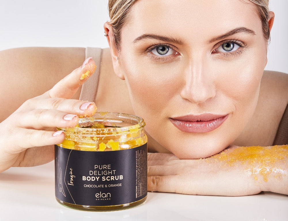 Chocolate and orange body scrub from Elan Skincare young beautiful woman exfoliating her body and hands, sugar scrub