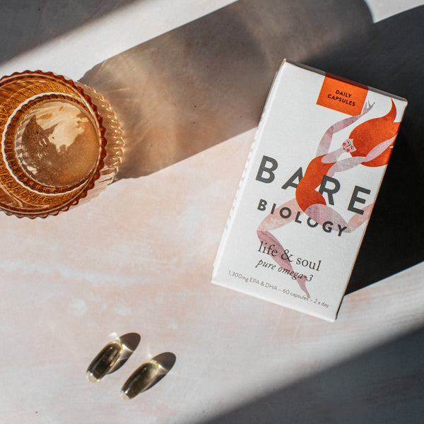 Pure OMEGA-3 60 Capsules from Bare Biology shown 2 capsules and external packaging on the table