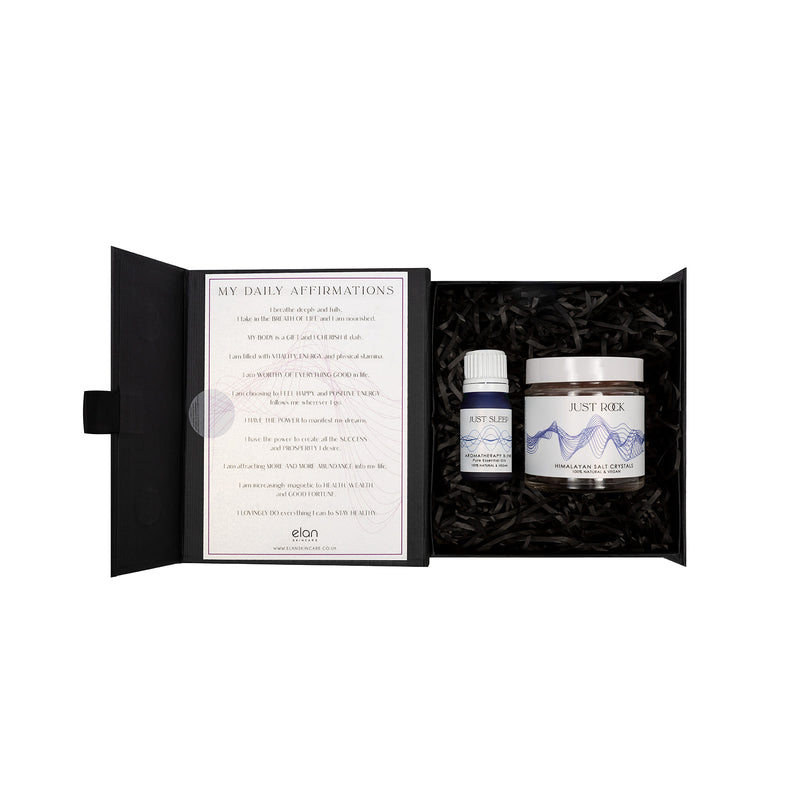 Sleep gift set from Elan Skincare, Aromatherapy blend of pure essential oils in a blue bottle, a jar of Himalayan salt crystals placed in a box, with my daily affirmations card fixed to the inside lid of the box 